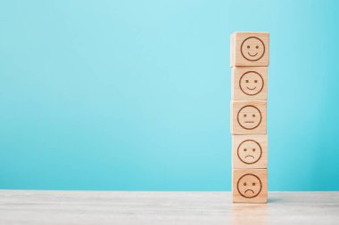 Mavi arka planda duygusal yüz blokları. Hizmet derecesi, sıralama, müşteri değerlendirmesi, memnuniyet, değerlendirme ve geri bildirim kavramı