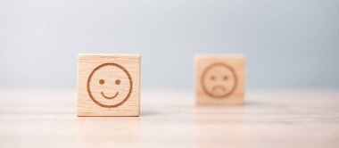 Tahta bloklardaki duygu simgesi. Hizmet derecesi, sıralama, müşteri değerlendirmesi, memnuniyet, değerlendirme ve geri bildirim kavramı