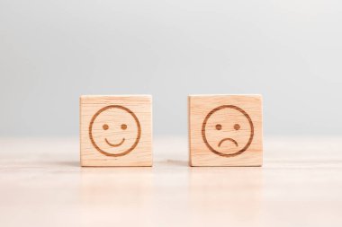 Tahta bloklardaki duygu simgesi. Hizmet derecesi, sıralama, müşteri değerlendirmesi, memnuniyet, değerlendirme ve geri bildirim kavramı