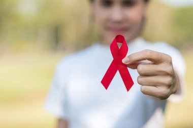 Red Ribbon 'ın elini tutarak yaşayan ve hastalığa yakalananları destekliyorum. Sağlık ve güvenli seks konsepti. Aralık Dünya Yardım Günü ve çoklu miyelom kanseri farkındalığı ayı