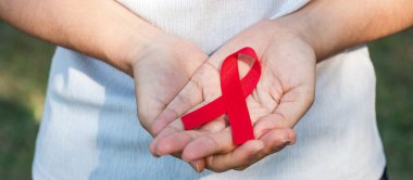 Red Ribbon 'ın elini tutarak yaşayan ve hastalığa yakalananları destekliyorum. Sağlık ve güvenli seks konsepti. Aralık Dünya Yardım Günü ve çoklu miyelom kanseri farkındalığı ayı