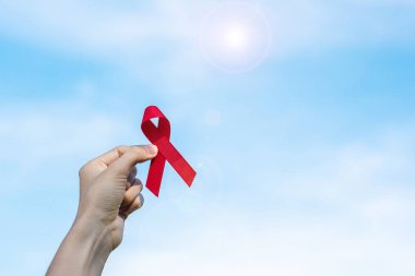 Red Ribbon 'ın elini tutarak yaşayan ve hastalığa yakalananları destekliyorum. Sağlık ve güvenli seks konsepti. Aralık Dünya Yardım Günü ve çoklu miyelom kanseri farkındalığı ayı