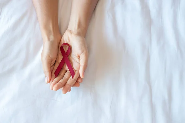 勃艮第红丝带用来支持生活和生病的人 卫生保健和安全性行为概念 12月世界艾滋病日和多个骨髓瘤认识月 — 图库照片