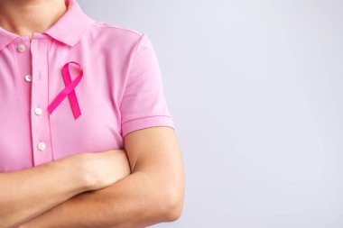 Pink October Breast Cancer Awareness month, woman hand hold pink Ribbon and wear shirt for support people life and illness. National cancer survivors month, Mother and World cancer day concept