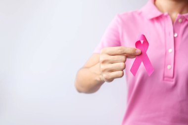 Pink October Breast Cancer Awareness month, woman hand hold pink Ribbon and wear shirt for support people life and illness. National cancer survivors month, Mother and World cancer day concept