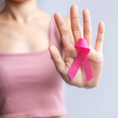 Pink October Breast Cancer Awareness month, woman hand hold pink Ribbon and wear shirt for support people life and illness. National cancer survivors month, Mother and World cancer day concept