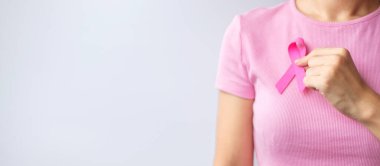Pink October Breast Cancer Awareness month, woman hand hold pink Ribbon and wear shirt for support people life and illness. National cancer survivors month, Mother and World cancer day concept