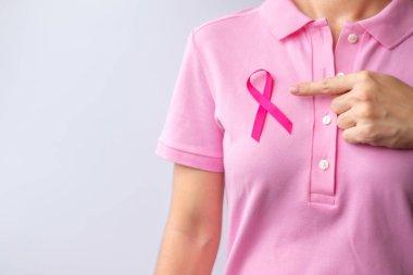 Pink October Breast Cancer Awareness month, woman hand hold pink Ribbon and wear shirt for support people life and illness. National cancer survivors month, Mother and World cancer day concept
