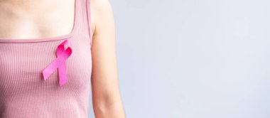 Pink October Breast Cancer Awareness month, woman hand hold pink Ribbon and wear shirt for support people life and illness. National cancer survivors month, Mother and World cancer day concept