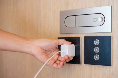 Closeup finger unplugging or plugging of electricity device at home. Energy Saving, power, electrical and lifestyle concepts