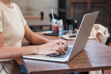 Casual Businesswoman using laptop, freelance woman typing keyboard computer notebook in cafe or modern office. technology, digital online and network concept