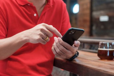 SMS mesajları için akıllı telefonu tutan ve kullanan sıradan bir iş adamı, kafede ya da modern ofiste dokunmatik cep telefonu yazan bir genç. yaşam tarzı, teknoloji, sosyal medya ve ağ kavramı