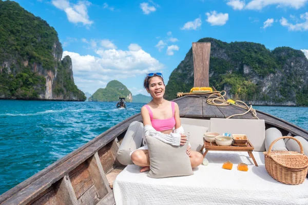 Woman tourist in private longtail boat trip to island with exotic food picnic, Krabi, Thailand. landmark, destination, Asia Travel, vacation, wanderlust and holiday concept