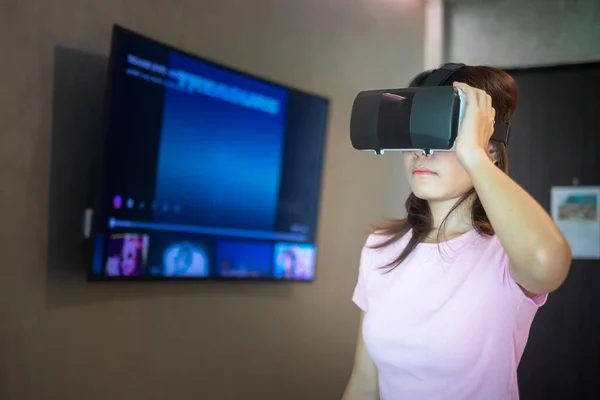 Young woman using virtual reality headset. VR, Future digital technology, game, movies entertainment, metaverse, NFT and 3D cyberspace concept