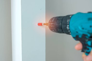 Evde mobilya montajı yapan kablosuz tornavida kullanan bir adam, işte elektrikli tornavida kullanan bir marangoz.