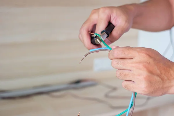 Electrician cuts electrical wires with pliers, Wiring cables installation for socket plug. Fixing, Renovation, Repair, service and development of home and apartment concepts