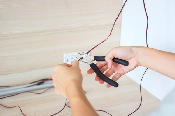 Electrician cuts electrical wires with pliers, Wiring cables installation for socket plug. Fixing, Renovation, Repair, service and development of home and apartment concepts