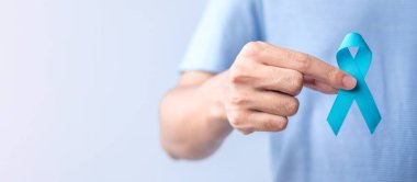 Blue November Prostate Cancer Awareness month, Man in blue shirt with hand holding Blue Ribbon for support people life and illness. Healthcare, International men, Father, Diabetes and World cancer day