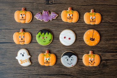 Ahşap masa arkasında komik kurabiyelerle Cadılar Bayramı 'nız kutlu olsun. Trick or Threat, Hello October, güz, şenlik, parti ve tatil konsepti