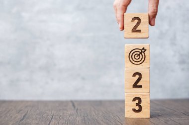 Dart tahtası işaretli 2023 blok. İş Amacı, Hedef, Çözüm, Strateji, Plan, Eylem motivasyonu, Görev, Düşünce ve Yeni Yıl Başlangıç kavramları