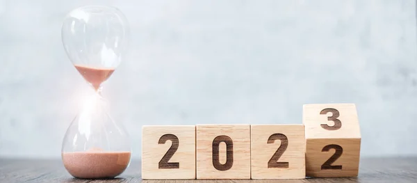 flip block 2022 to 2023 text with hourglass on table. Resolution, time, plan, goal, motivation, reboot, countdown  and New Year holiday concepts