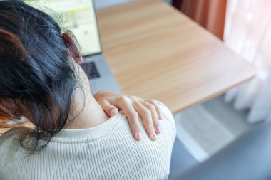 İş yerinde uzun süre Neck ve Omuz ağrısı çeken bir kadın. Fibromiyalji, romatizma, skapüler ağrı, ofis sendromu ve ergonomik konsept yüzünden.