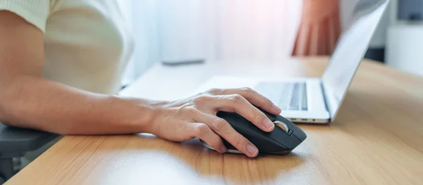 woman hand using ergonomic vertical mouse during working on Adjustable desk, prevention wrist pain. De Quervain s tenosynovitis, Intersection Symptom, Carpal Tunnel or Office syndrome concept