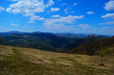Gün batımında dağlarda kırsal manzara. Karpatların güzel manzarası. Akşam vakti çayırları ormanlık tepelerde yuvarlanıyor. İlkbaharda harika bir hava