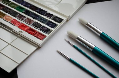 Birçok araç gereç sanatçılar fırçalar suluboya kutu boyaları beyaz izole arka plan