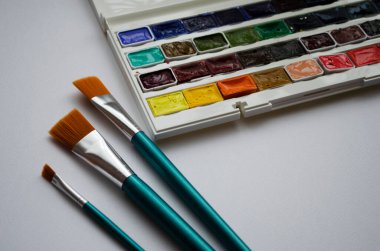 Birçok araç gereç sanatçılar fırçalar suluboya kutu boyaları beyaz izole arka plan