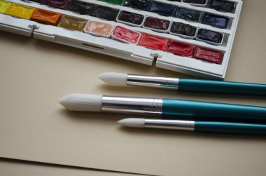 Birçok araç gereç sanatçılar fırçalar suluboya kutu boyaları beyaz izole arka plan