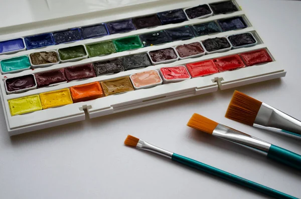 Birçok araç gereç sanatçılar fırçalar suluboya kutu boyaları beyaz izole arka plan
