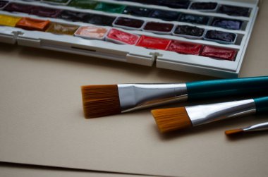 Birçok araç gereç sanatçılar fırçalar suluboya kutu boyaları beyaz izole arka plan