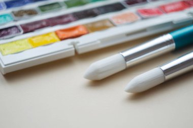 Birçok araç gereç sanatçılar fırçalar suluboya kutu boyaları beyaz izole arka plan