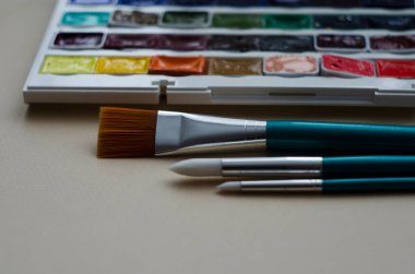 Birçok araç gereç sanatçılar fırçalar suluboya kutu boyaları beyaz izole arka plan