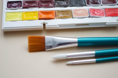 Birçok araç gereç sanatçılar fırçalar suluboya kutu boyaları beyaz izole arka plan