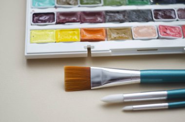 Birçok araç gereç sanatçılar fırçalar suluboya kutu boyaları beyaz izole arka plan