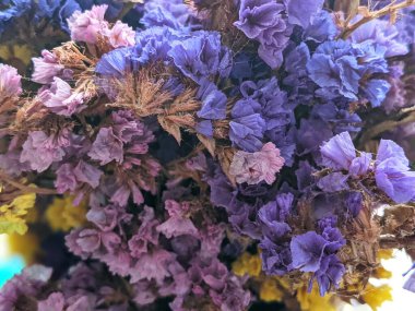 Limonyum sinuatum (çentikli yaprak bataklık biberiyesi, deniz lavantası, deniz pembesi, statik deniz lavantası) rengarenk buketi ve hasır şapka. Yaz estetik bileşimi.