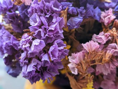 Limonyum sinuatum (çentikli yaprak bataklık biberiyesi, deniz lavantası, deniz pembesi, statik deniz lavantası) rengarenk buketi ve hasır şapka. Yaz estetik bileşimi.