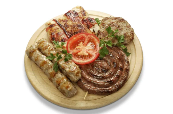 Mixed grill of pork on a wooden mat — Stock Photo, Image