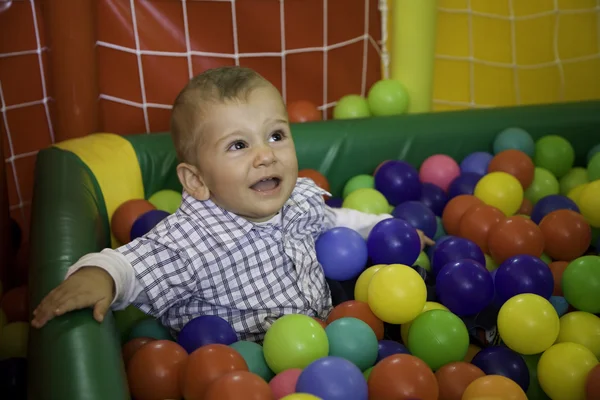 Little boy crying among colored balls game — Stock Photo, Image