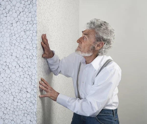 old man put his hand on the wall