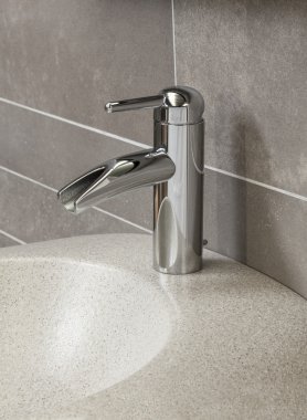 Banyo içi beyaz lavabo ve muslukla dolu.