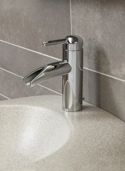 Banyo içi beyaz lavabo ve muslukla dolu.