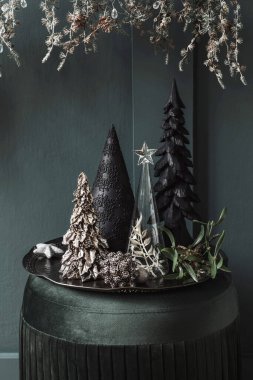 Oturma odasındaki yeşil kadife pouf 'un Noel kompozisyonu. Güzel dekorasyon. Noel ağaçları, mumlar, yıldızlar, ışıklar ve zarif aksesuarlar. Mutlu Noeller ve Mutlu Noeller Şablonlar. 