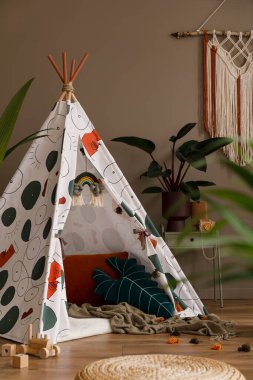 Şapkası, bitkileri, oyuncakları, asılı süslemeleri ve aksesuarları olan şık çocuk odası iç tasarımının yaratıcı kompozisyonu. Retro ve klasik konsept. Kahverengi duvarlar, parke zemin. Şablon.