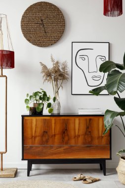 Şık oturma odası iç tasarımının yaratıcı kompozisyonu poster çerçevesi, ahşap tuvalet, bitkiler, asma dekorasyonu ve aksesuarlarıyla. Retro ve klasik konsept. Şablon.