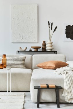 Poster çerçevesi ve yapı boyası, köşedeki kanepe, sehpa, tekstil ve kişisel aksesuarları olan yaratıcı bir iç mekan. İskandinav klasiği.