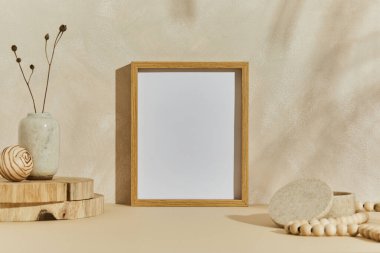 Poster çerçevesi, ahşap ve marbel olarak doğal malzemeler, kuru bitkiler ve kişisel aksesuarlarla süslenmiş rahat minimalist iç tasarımın şık bileşimi. Nötr bej renkler, şablon.