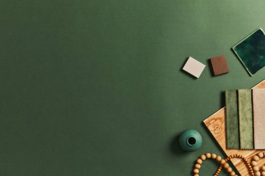 Yapı, tekstil ve doğal malzemeler ve kişisel aksesuarlar örnekleriyle yaratıcı mimarın modun tasarımının şık düz yapısı. Üst görünüm, yeşil arkaplan, şablon.